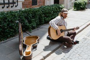 Man in Brown and White Stripes Dress Shirt Playing Brown Acoustic Guitar
